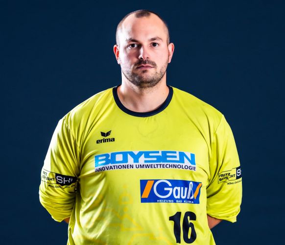 Mann im gelben Sporttrikot mit der Nummer 16 vor dunkelblauem Hintergrund.